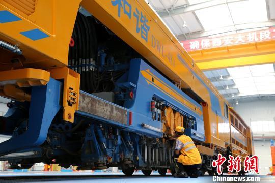 圖為工人正在清理大型養(yǎng)路機械?！堖h 攝